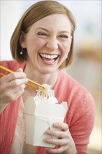 Woman eating Chinese take out food.