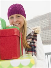 Woman holding christmas gifts. Photo : Jamie Grill Photography