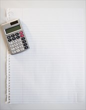 Studio shot of calculator on sheet of paper. Photo : Jamie Grill Photography
