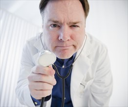 Doctor holding stethoscope. Photo : Jamie Grill Photography