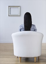 Rear view of woman sitting in armchair. Photo: Daniel Grill
