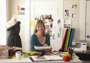Portrait of female fashion designer working in studio. Photo : DreamPictures