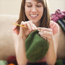 Young woman knitting woolly hat. Photo: Mike Kemp