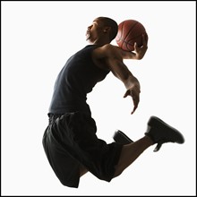 Studio shot of young man playing basketball. Photo : Mike Kemp