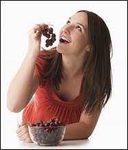 Young woman eating grapes. Photo: Mike Kemp