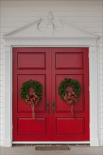 USA, San Francisco, Christmas wreath on red doors. Photo: Noah Clayton