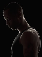 Studio shot of muscular young man wearing tank top. Photo : Mike Kemp