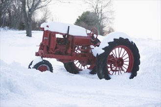 USA, New York, Cutchoge, old tractor covered in snow. Photo: fotog