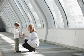 Female doctor talking to boy (6-7) in corridor. Photo: Mark Edward Atkinson