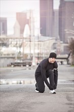 USA, Washington, Seattle, man tying shoelace in street. Photo : Take A Pix Media