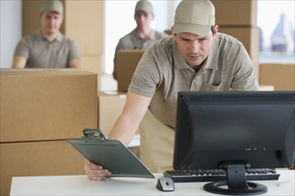 Man checking checklist in warehouse.