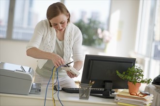 Woman installing router at home office.