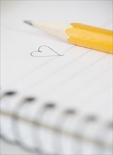 Close-up of pencil and notebook with heart drawing. Photo : Jamie Grill Photography