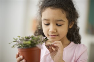 Portrait of girl (6-7) holding potted plant.