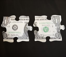 Studio shot of jigsaw pieces depicting one dollar bill. Photo: Jamie Grill Photography