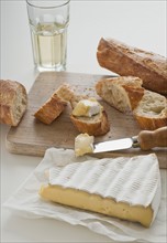 Cheese and baguette on table.