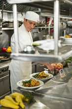 Chef preparing food in kitchen.