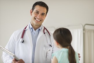 Portrait of doctor talking to girl (8-9).