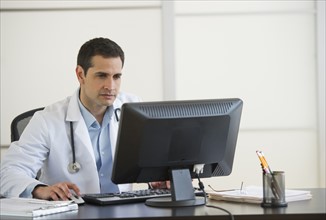 Doctor using computer in office.