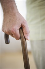 Close-up of senior man's hand on cane.