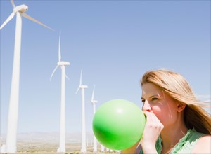 USA, California, Palm Springs, Coachella Valley, San Gorgonio Pass, Woman blowing green balloon