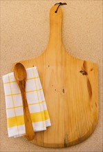 Wooden chopping board, spoon ad checked napkin. Photo : Daniel Grill
