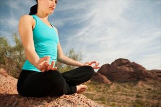 USA, Arizona, Phoenix, Young woman practicing yoga on desert.