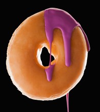 Studio shot of doughnut with purple paint. Photo : Mike Kemp
