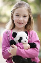 Portrait of girl (4-5) holding toy panda. Photo : Rob Lewine