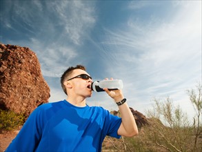 USA, Arizona, Phoenix, Man drinking from bottle .
