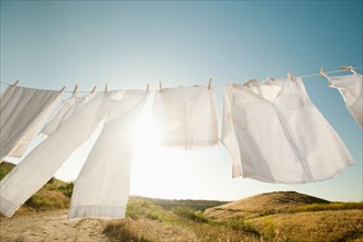 Laundry hanging on clothesline against blue sky.