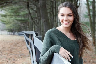 USA, New Jersey, Califon, Teenage girl (16-17) standing near fence and looking at camera, portrait.