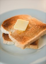Close up of toasts with butter on plate. Photo : Jamie Grill Photography