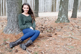 USA, New Jersey, Califon, Teenage girl (16-17) sitting in forest, portrait. Photo : Pauline St