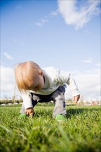 Baby boy (0-1 years) on grass. Photo : Maisie Paterson