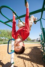 USA, California, Boy (12-13) climbing at playground. Photo : Noah Clayton