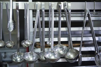Close up ladles in commercial kitchen.