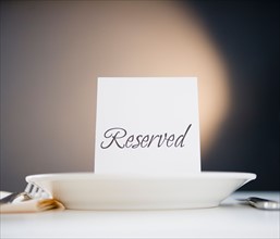Reserved sign on place setting, studio shot. Photo : Jamie Grill Photography