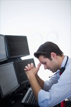 Upset financial worker analyzing data displayed on computer screen.