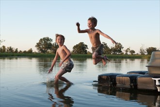 USA, Texas, Texarkana, Two boys (8-9) jumping into lake. Photo : King Lawrence