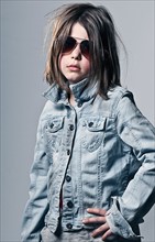 Girl (8-9) posing in oversized denim jacket an sunglasses . Photo : Justin Paget