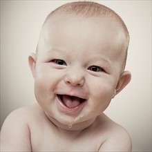 Studio portrait of baby boy (6-11 months) smiling. Photo : King Lawrence