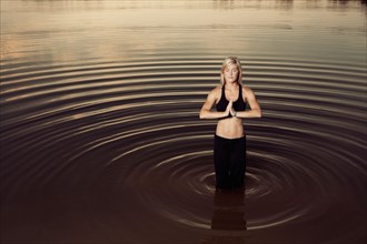 Woman doing yoga in lake. Photo : King Lawrence