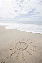 USA, Massachusetts, Sun drawn on sandy beach. Photo : Chris Hackett