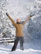 USA, Colorado, young woman throwing snow in air. Photo : John Kelly