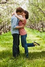 USA, Utah, Provo, Young couple kissing in orchard. Photo : Mike Kemp