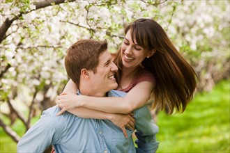 USA, Utah, Provo, Young couple embracing in orchard. Photo : Mike Kemp