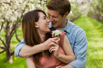 USA, Utah, Provo, Young couple with blossom in orchard. Photo : Mike Kemp