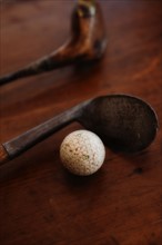 Close up of antique golf clubs and golf ball.