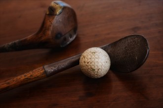 Close up of antique golf clubs and golf ball.